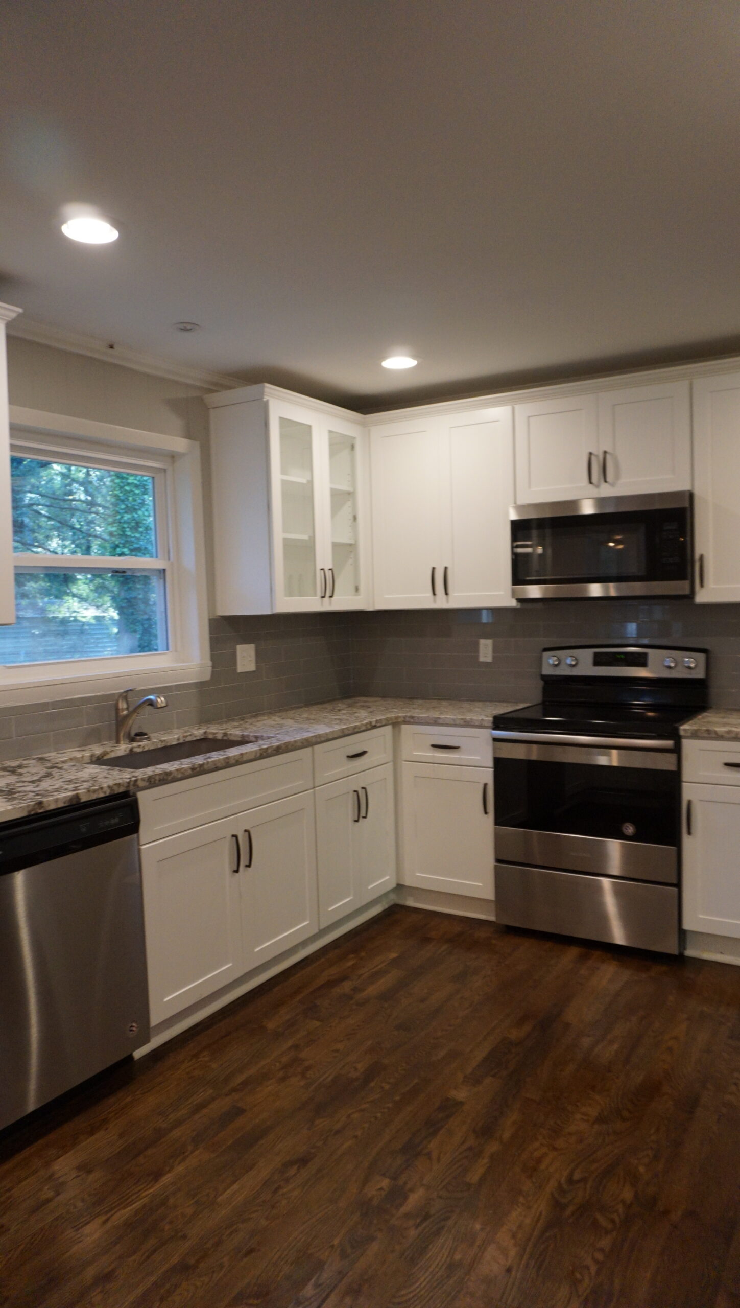 Kitchen after full gut renovation Atlanta GA — white shaker cabinets, granite countertops, stainless appliances