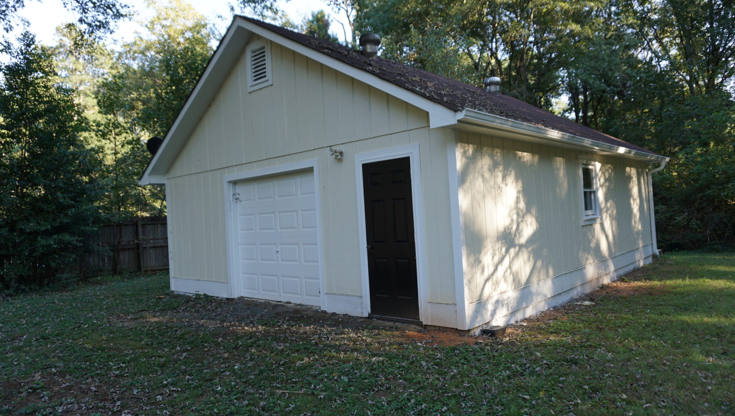 Detached workshop exterior renovation Atlanta GA — painted, garage door, clean yard